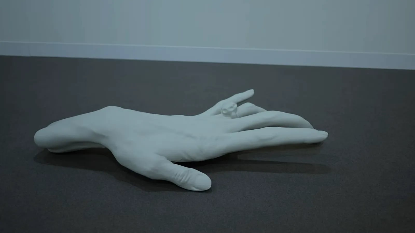 Weiße Skulptur einer liegenden Hand auf der Art Basel