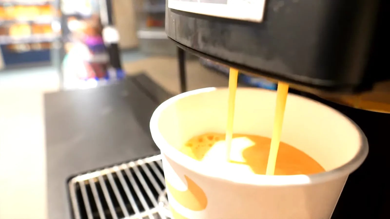 Kaffee läuft aus dem Automaten in einen Pappbecher