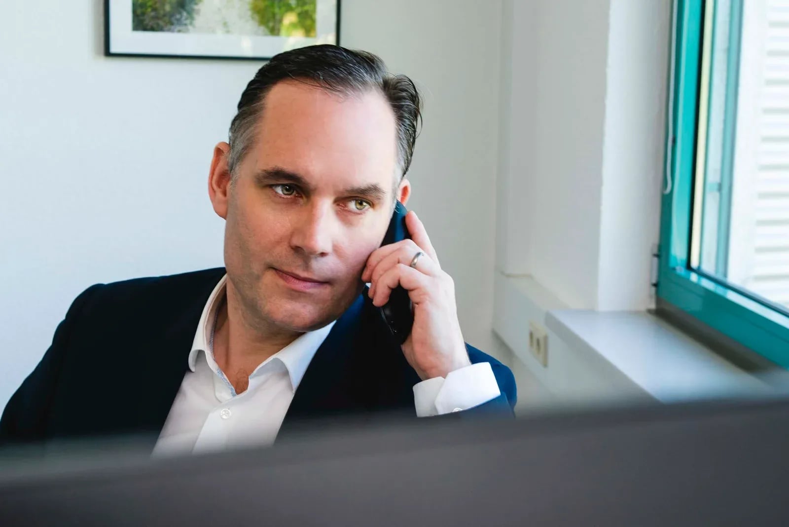 Der Unternehmer telefoniert, über den Bildschirmrand aufgenommen