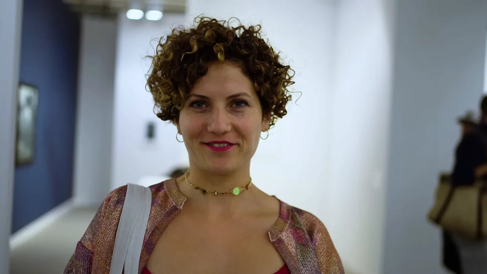Eine Besucherin mit Locken und Halskette auf der Kunstmesse