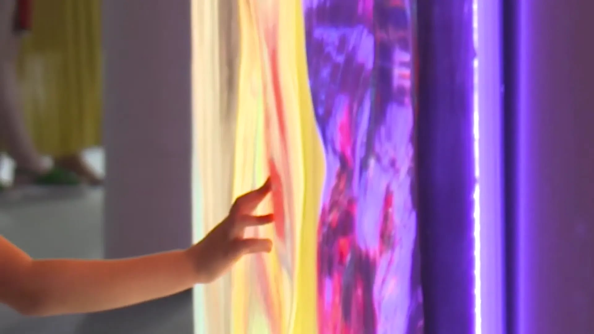Eine Hand berührt eine leuchtende Lichtinstallation