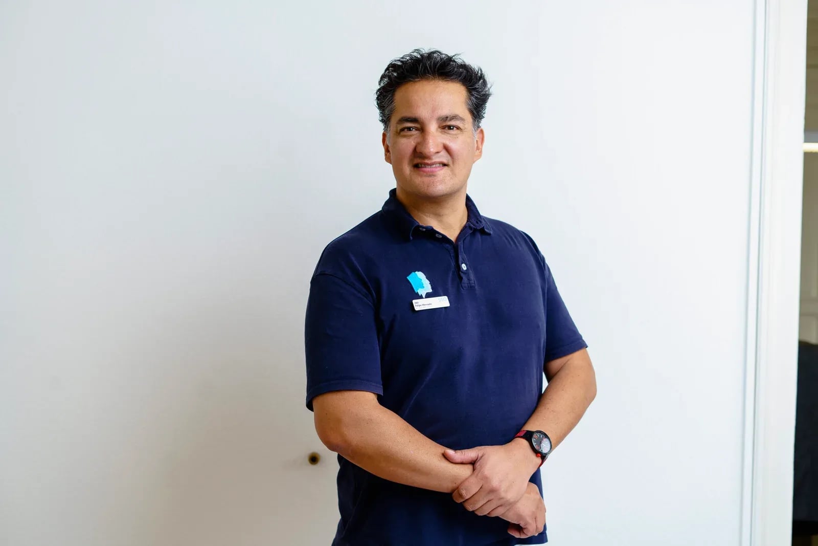 Porträt eines Mitarbeiters im dunkelblauen Poloshirt