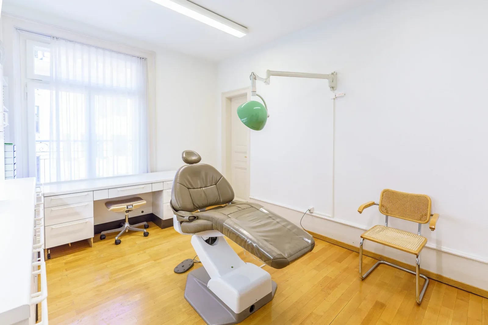 Behandlungszimmer mit grüner Leuchte und Holzboden